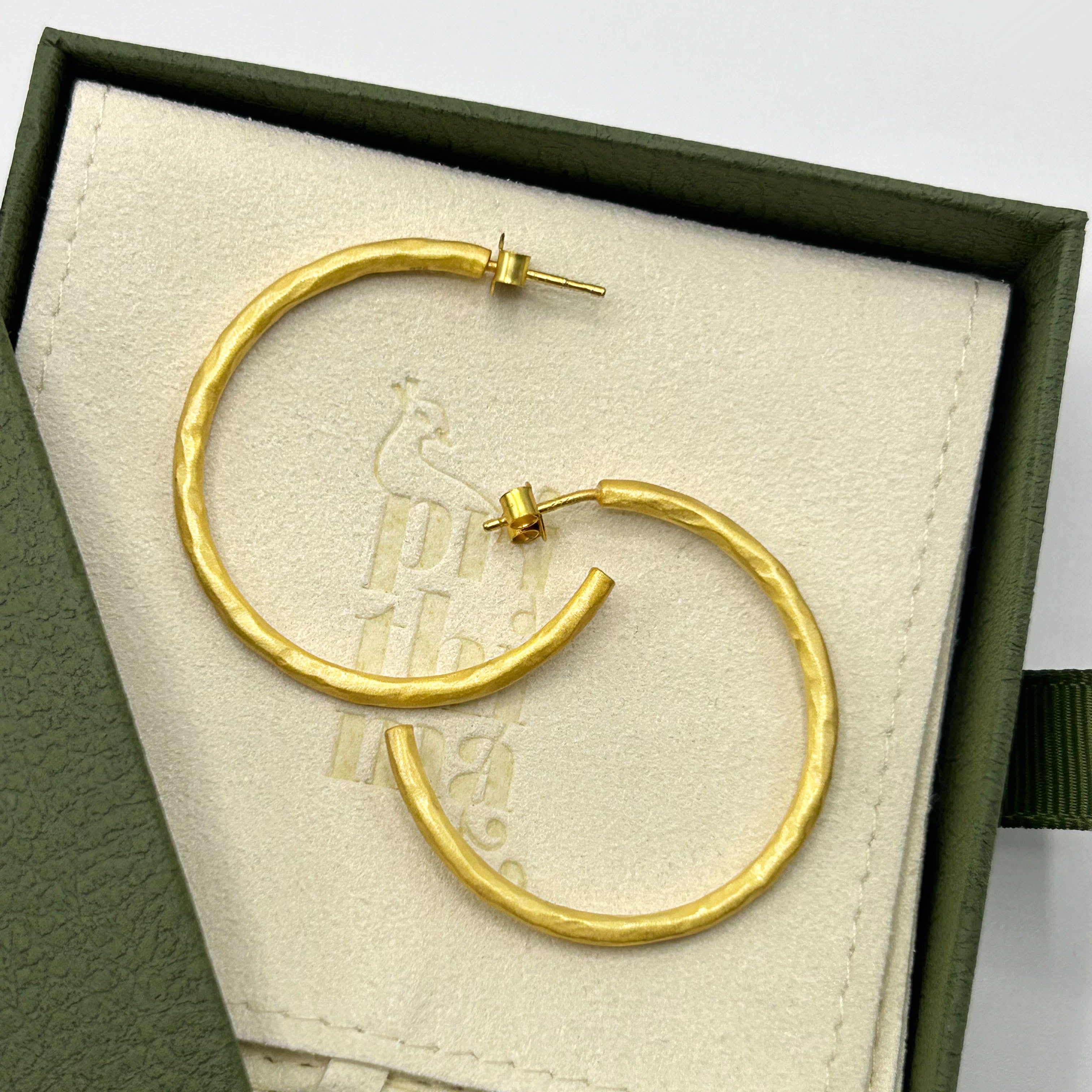 Vergoldete Creolen in einer Schmuckbox