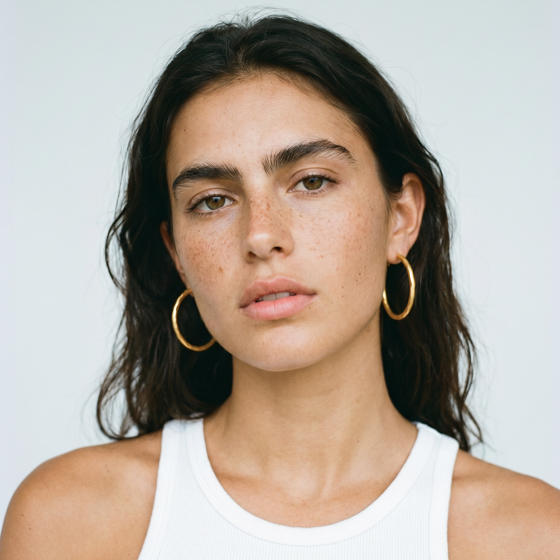 Portrait shoot einer dunkelhaarigen Frau mit goldenen Hop Ohrringen